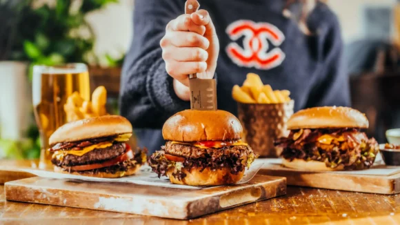 Selection of burgers on a wooden board with fries at The Hercules Pillars, a pub near Holborn station