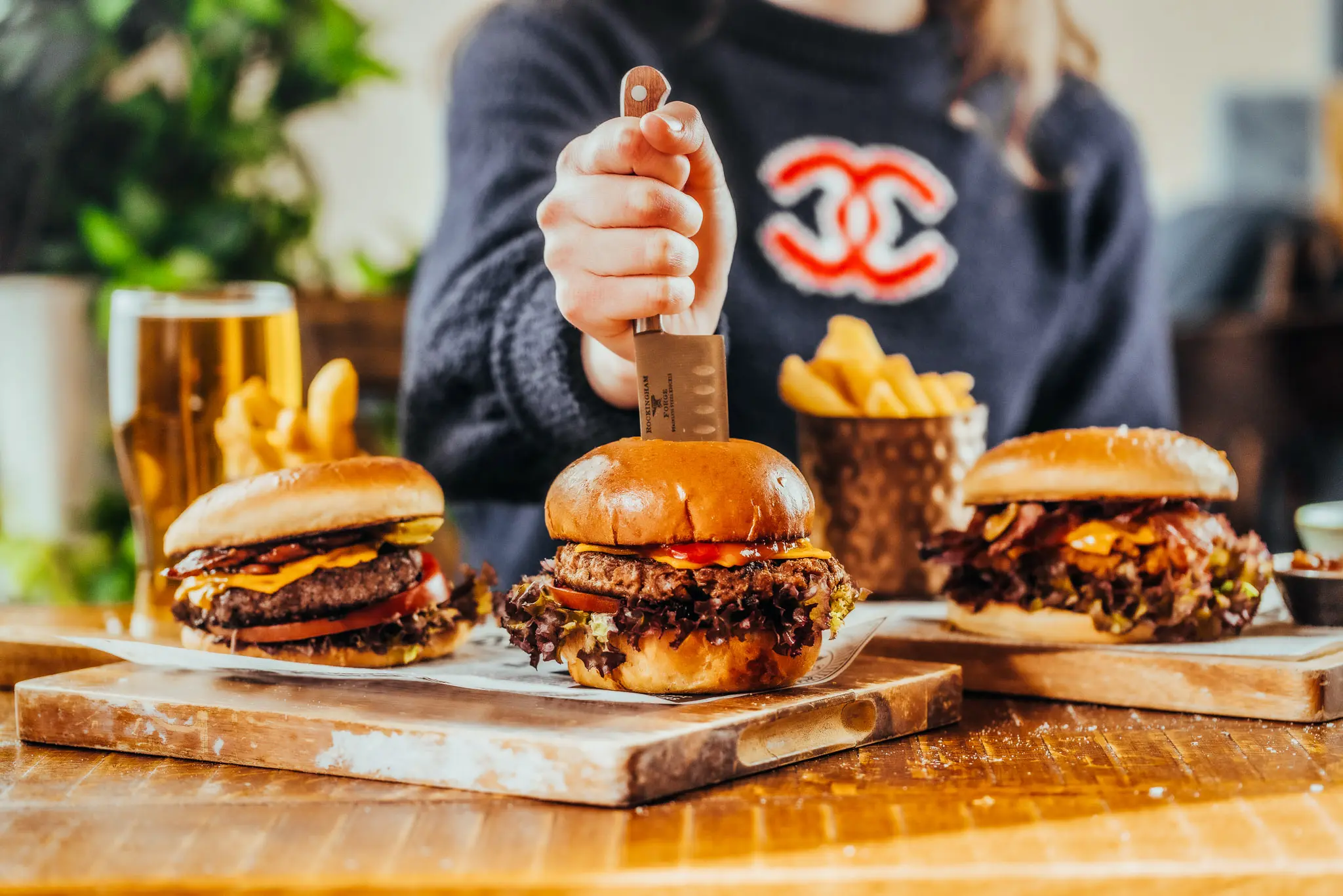 Selection of burgers on a wooden board with fries at The Hercules Pillars, a pub near Holborn station