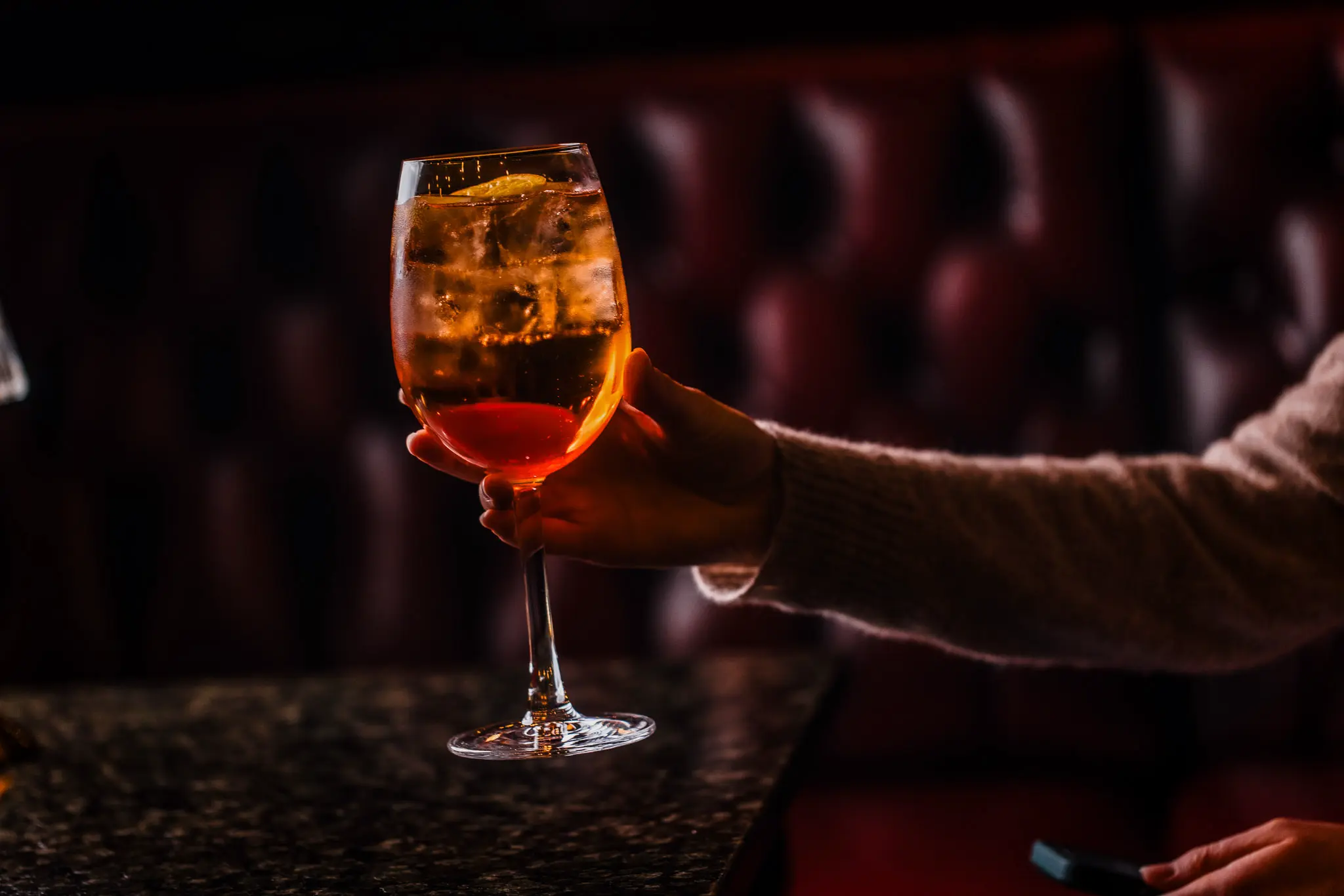 Aperol spritz cocktail held at the bar at The Hercules Pillars pub, Holborn, London