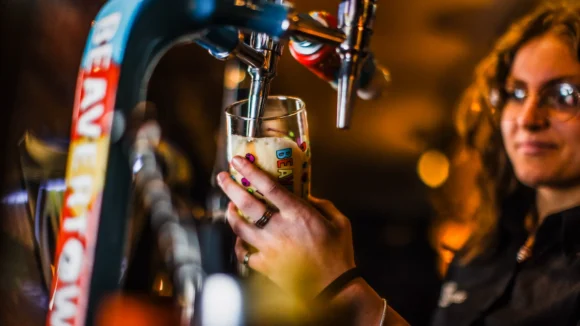 Bar staff pouring a draught beer at The Hercules Pillars, a traditional pub near Holborn station, London