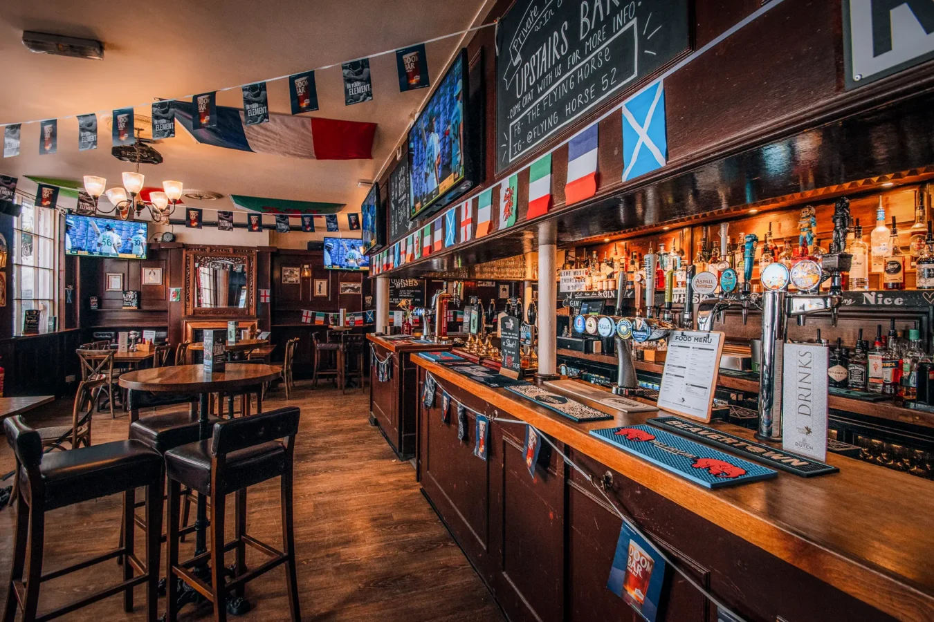 The bar and interior of The Flying Horse pub on Wilson Street, EC2A, showing HD sport screens and draught beer taps
