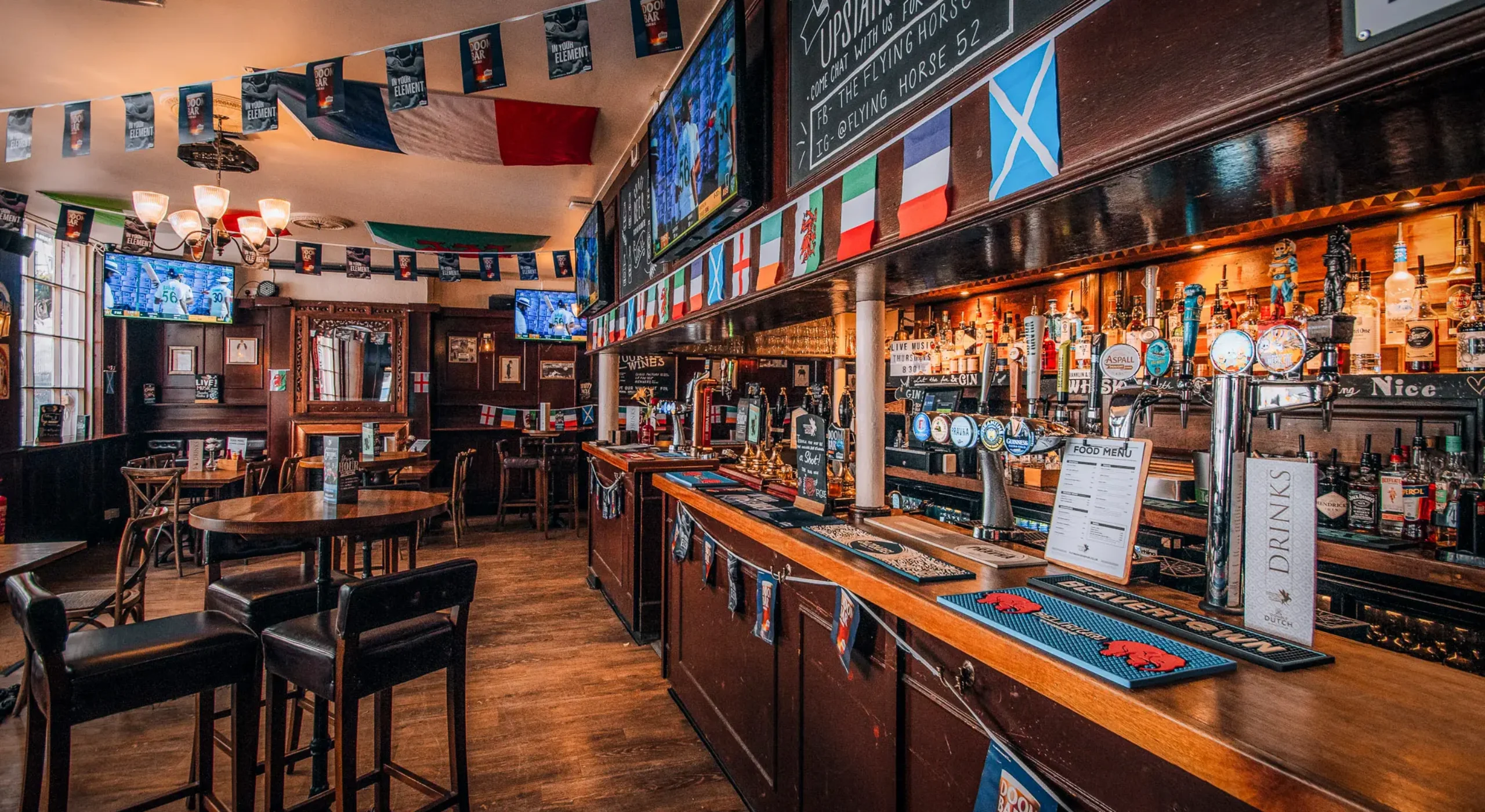 The bar and interior of The Flying Horse pub on Wilson Street, EC2A, showing HD sport screens and draught beer taps