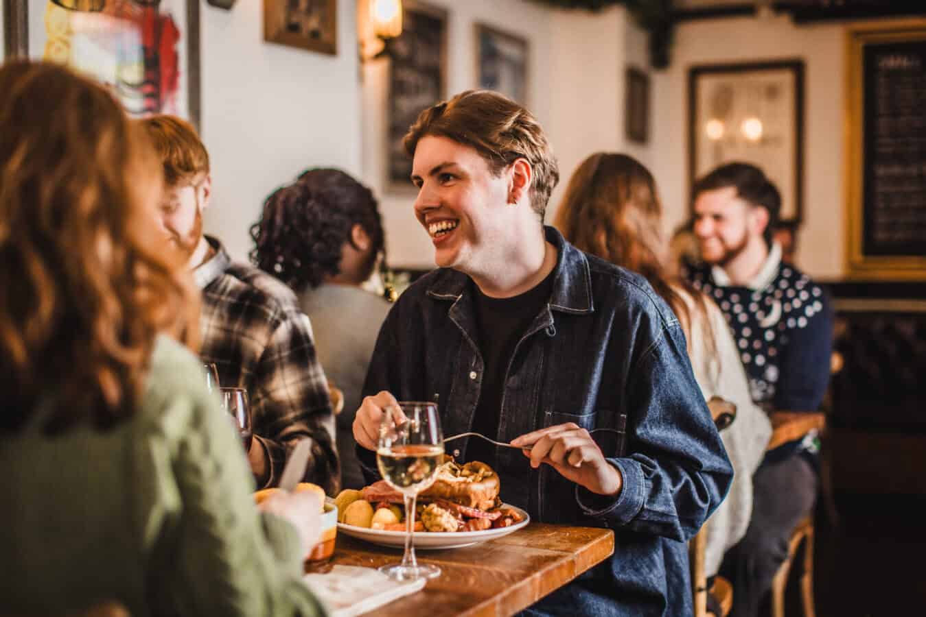 Happy guests enjoying food and drinks at The Flying Horse pub.