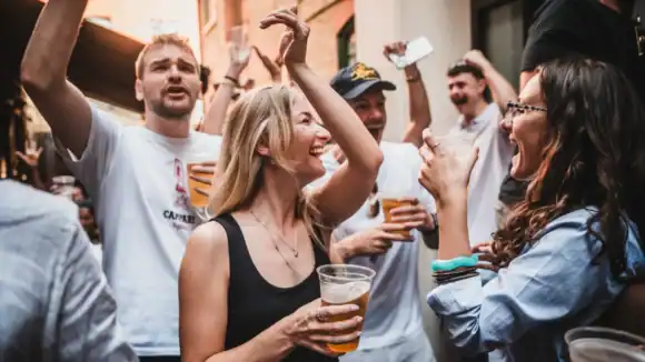 People enjoying drinks and celebrating outside The Flying Horse pub.