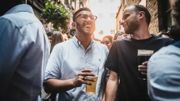 People enjoying drinks at The Flying Horse pub in a lively outdoor setting.